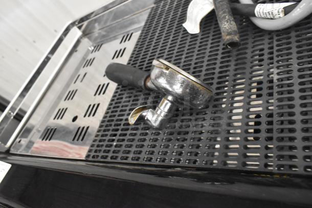 Faema Teorema stainless steel espresso machine with portafilter visible, features 2 groups, 3 portafilters, and 2 steam wands.