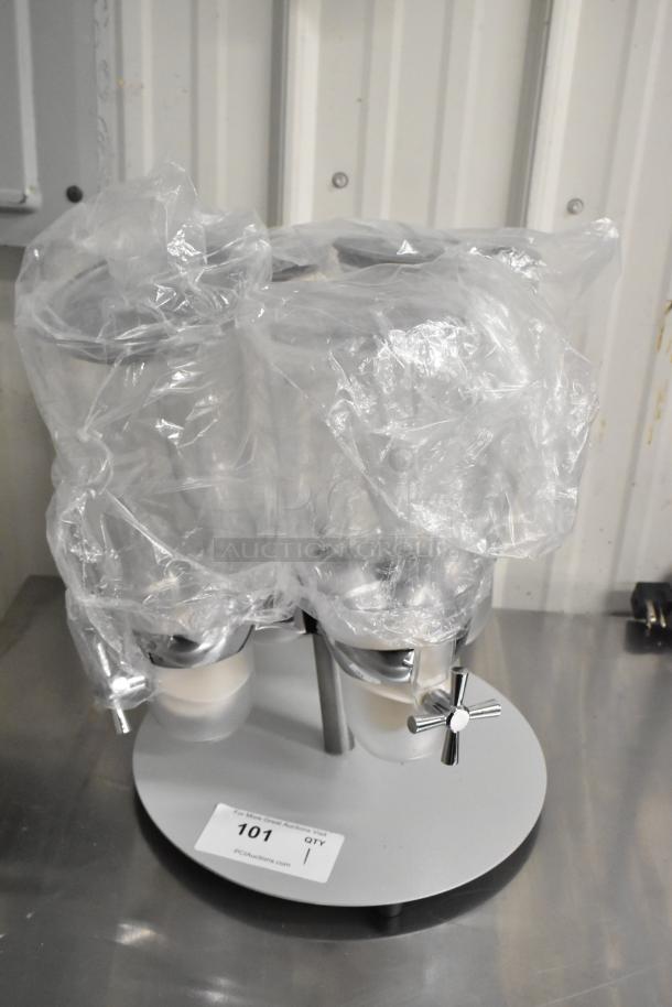 Brand new clear poly 4-hopper dry goods dispenser with one cracked hopper, covered in protective plastic wrap. Marked item 101.