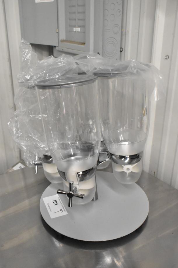 Brand new 4-hopper poly dry goods dispenser. One hopper cracked. Scratch and dent condition. Clear with chrome accents.