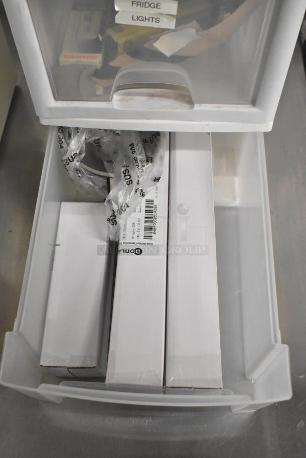 Clear and white poly bin containing various items, including labeled boxes and bags, with visible "Fridge" and "Lights" labels.