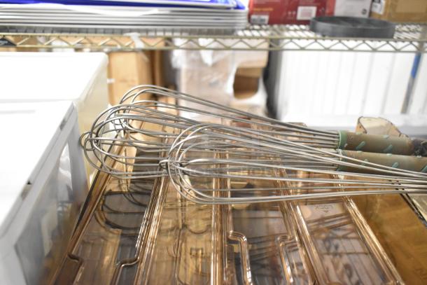 Lot including metal whisks and amber-colored poly hoppers, used condition, suitable for kitchen or industrial use.