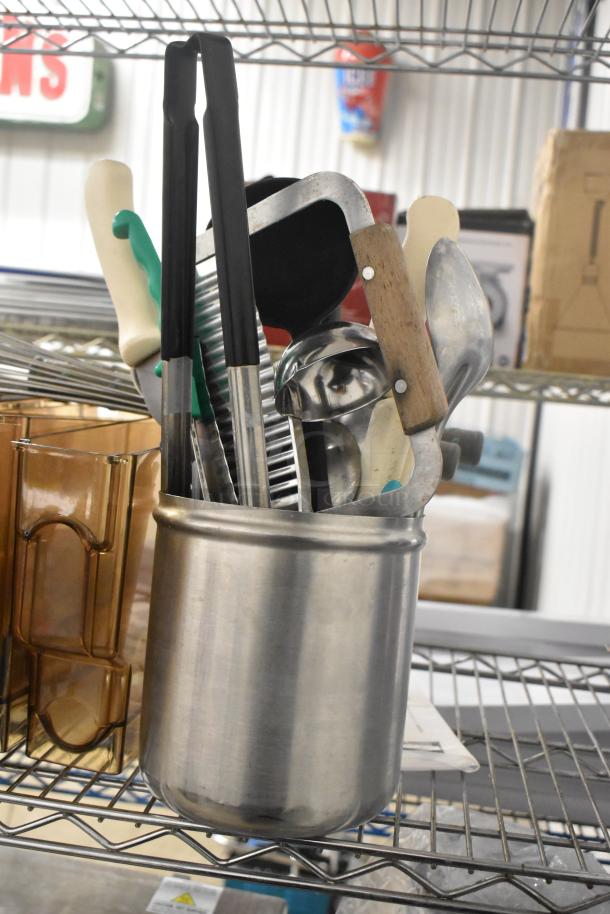 Lot of various kitchen utensils and amber poly hoppers on a metal shelf. Includes tongs, peelers, and more. Good condition.