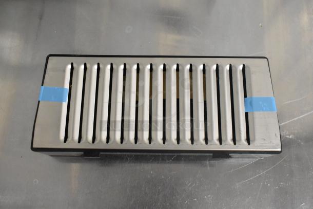 Stainless steel drip tray with slotted design, accented with blue tape. Part of an auction lot with Rapid Cool bottles.