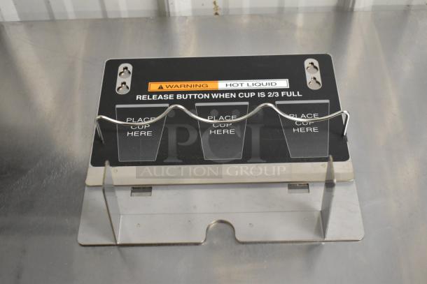 Stainless steel drip tray with cup holder slots, marked with "Warning Hot Liquid" and cup placement guides.