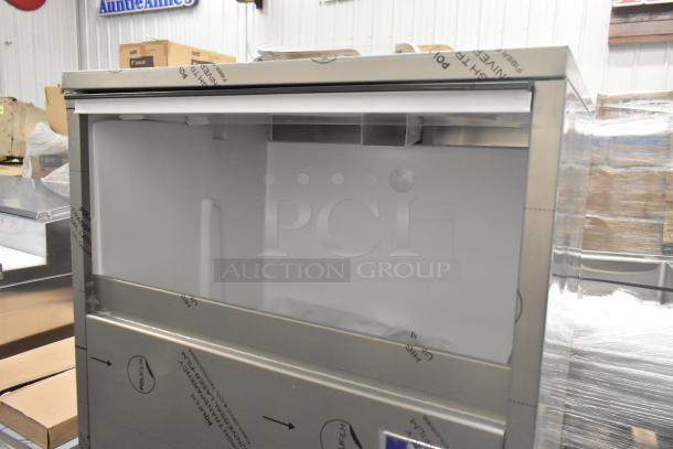 Brand new Manitowoc UNP0300A-161 stainless steel undercounter nugget ice machine, 325 lb capacity; minor dents visible.