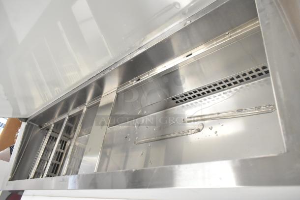 Brand new Avantco 178SSPPT260 stainless steel pizza prep table interior, features compartments, visible scratch and dent.