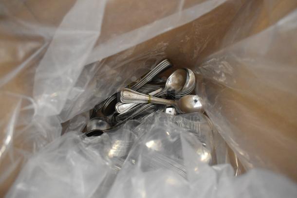 Bag of assorted silverware, including spoons, bundled together in plastic wrap. Possible scratch and dent condition.