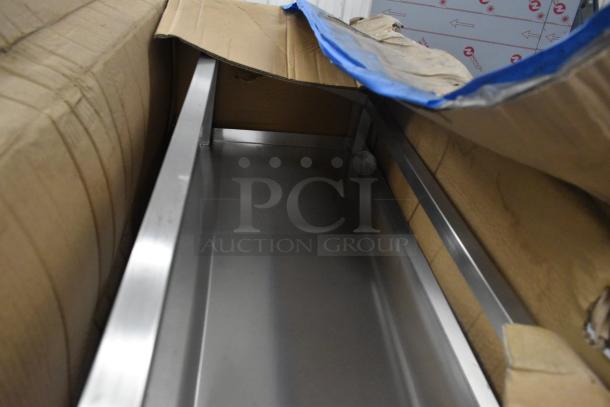 Cardboard packaging with visible dent holds shiny metal structure. Condition appears new with some cosmetic damage. Tags not visible.