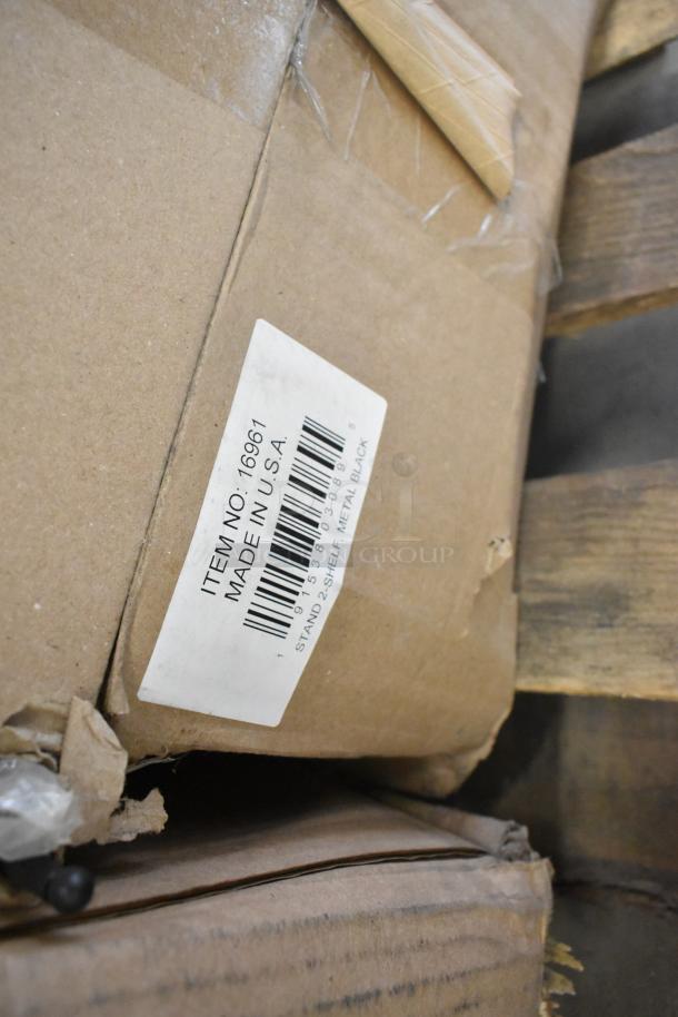 Cardboard box with a label stating "Item No: 16961, Made in U.S.A.," contains scratch and dent items like ceramic dishes.