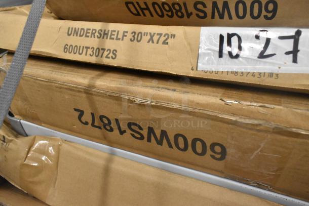 Boxes labeled "Undershelf 30x72" 600UT3072S" stacked, indicating new scratch and dent items including shelves and a work table.