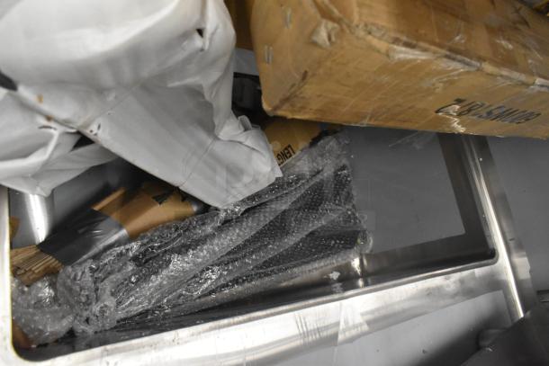 Items include a new stainless steel sink and boxed accessories. Scratch and dent condition visible on packaging.