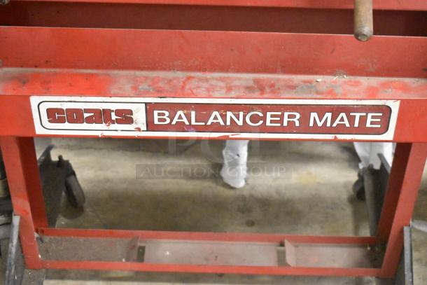 Coats red metal floor-style balancer on casters, labeled "Balancer Mate," shows moderate wear, ideal for automotive use.