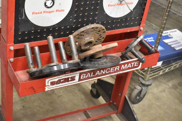 Coats Red Metal Floor Style Balancer Mate on Casters, includes fixed finger plates, visible wear, ideal for tire balancing.