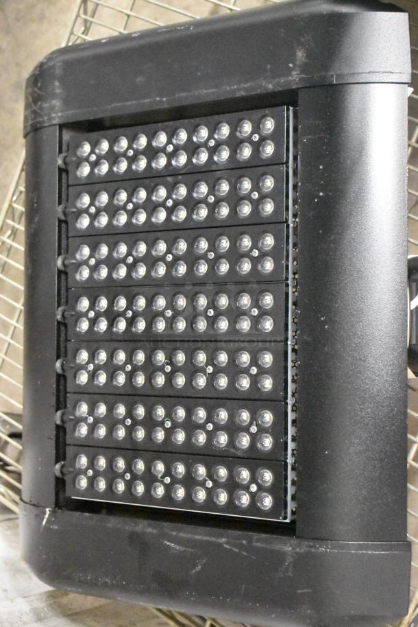 Brand new light fixture with multiple LED bulbs, black casing, minor scratches, and dents evident.