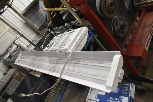 Brand new Westinghouse RMSP501D-08 5000 Lumen LED shop light and Lithonia light, minor dents, label lot 128.