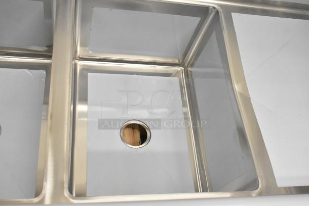 Brand new Regency 600S31824218 stainless steel 3 bay sink with dual drain boards, visible scratch marks. No legs.