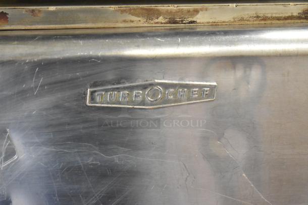 Turbochef HhC2020 stainless steel logo plate on a 2016 commercial conveyor oven, showing minor surface wear.