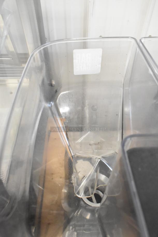 La Marzocco Swift E.P.S.B. commercial espresso grinder with dual hoppers, metal countertop design, clear plastic construction.