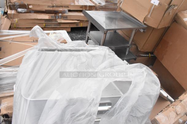 12 new scratch and dent items, including stainless steel hand sink and pot rack, in packaging. Boxes labeled with item codes.