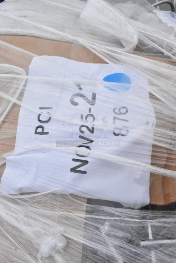 Packaging with label "NOV 25-23, PCI 876" wrapped in plastic, indicating auction items including Regency shopping cart.