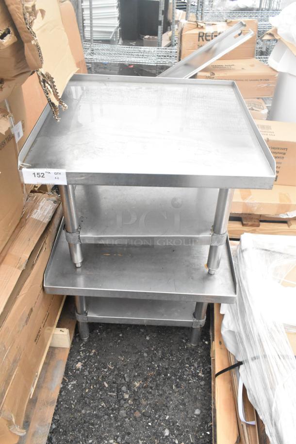 Two stainless steel commercial equipment stands with under shelves, shown stacked. Good condition with a label reading "152 IN QTY."