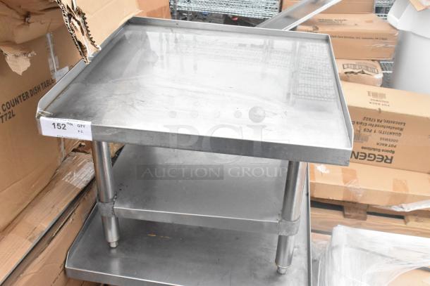 Stainless steel commercial equipment stand with under shelf; minor surface wear; labeled "152"; ideal for kitchen use.