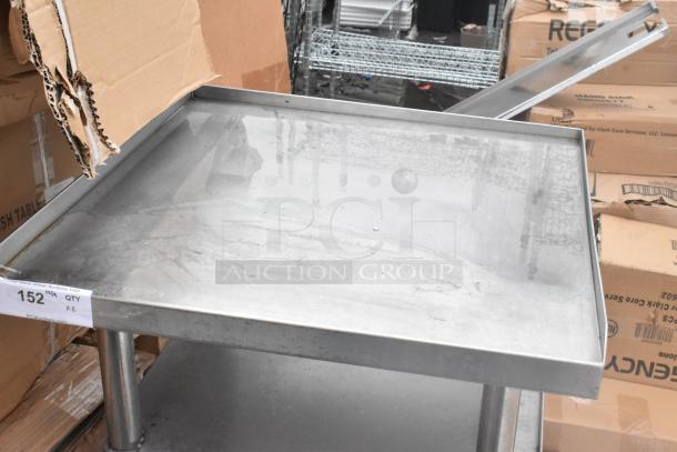 2 stainless steel commercial equipment stands with under shelves, with visible scratches and signs of use. Lot tag reads "152" and "QTY x2".