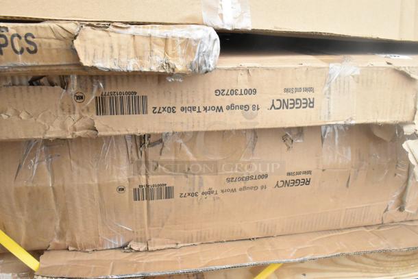 Cardboard boxes labeled "Regency 18 Gauge Work Table 30x72." Boxes show wear indicating scratch and dent condition.