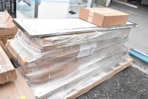 10 brand new scratch and dent items, including work table, wire shelf, and broiler stand, wrapped on pallet with labels.