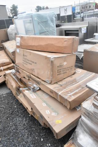 Stack of boxed items including Regency chrome shelves, new condition with visible dent marks. Tags indicate model and size.