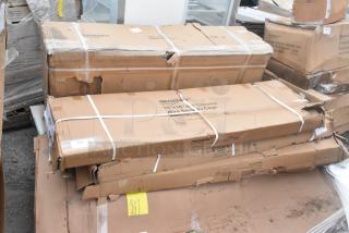 Cardboard boxes of scratch and dent items including a work table and Regency chrome wire security cage, visible damage.