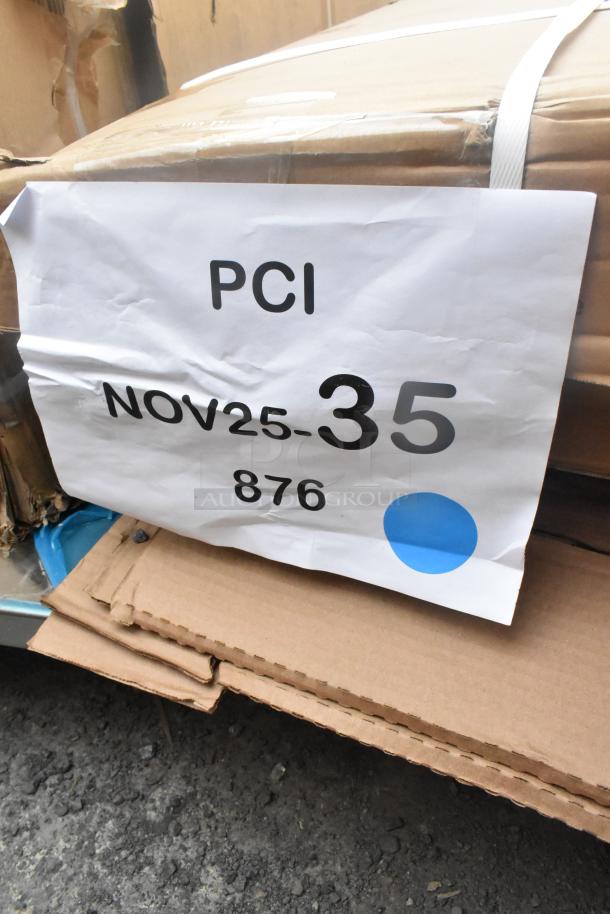 Cardboard boxes labeled "PCI NOV25-35 876" containing new scratch and dent items like a work table and security cage.