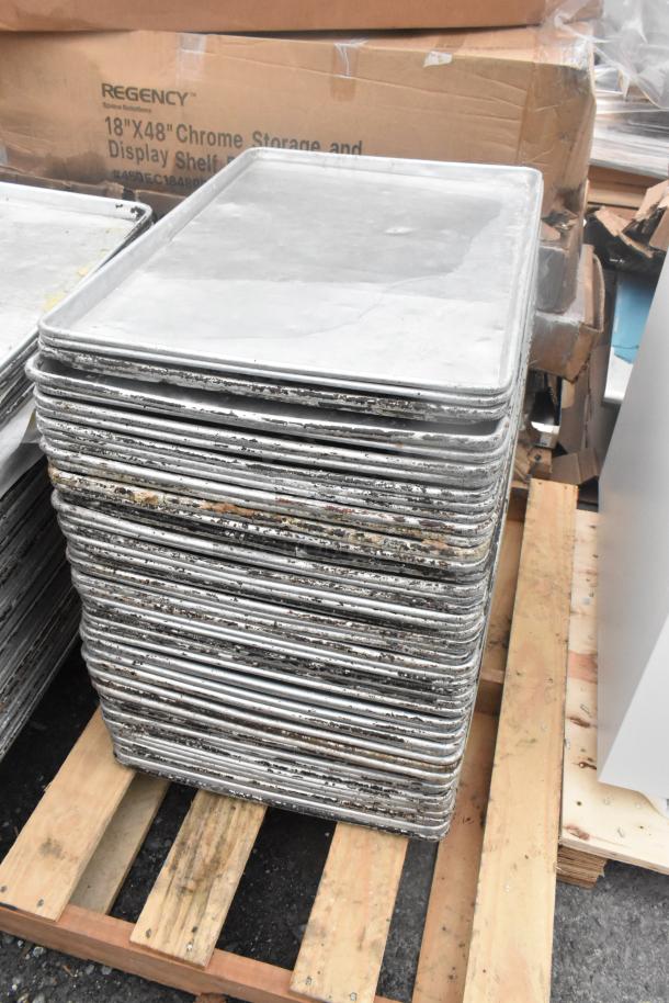 Stack of 106 used metal full-size baking pans on pallets, showing visible wear. Ideal for bulk purchase.