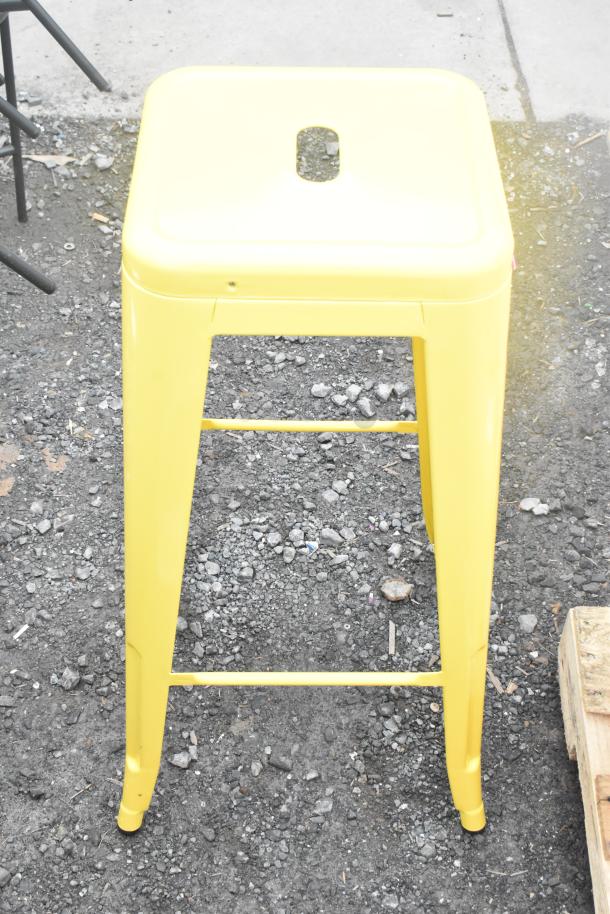 3 yellow Tolix style metal stools, stackable, sleek design, in mint condition. Ideal for modern or industrial interiors.