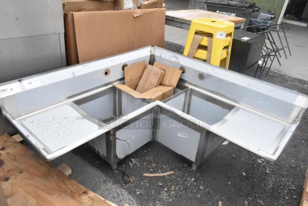 Regency 600S3181818C stainless steel L-shaped 3-bay sink with dual drain boards. New, with minor scratches and dents.