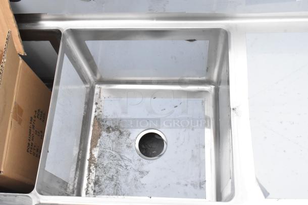 Brand new Regency 600S3181818C stainless steel L-shaped 3-bay sink with dual drain boards. Some scratches visible.