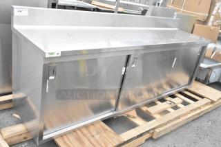 Brand new Regency 600EBTB2496D 24"x96" stainless steel enclosed table, sliding doors, adjustable midshelf, 6" backsplash.