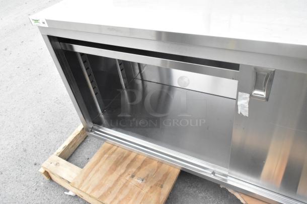 Brand new Regency 600EBTB2496D stainless steel table, 24"x96", with enclosed base, sliding doors, adjustable midshelf, 6" backsplash.