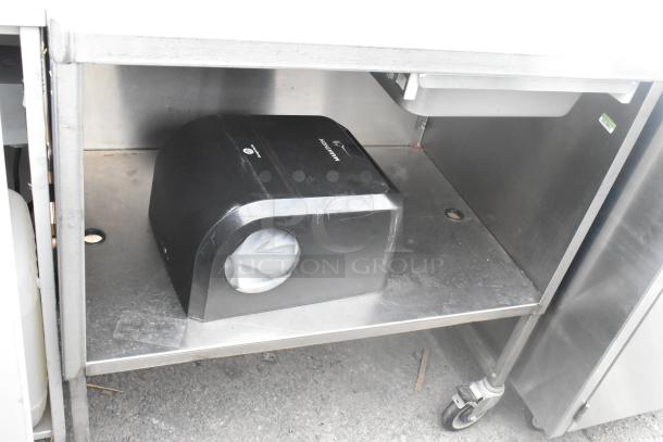Stainless steel table with drawer and under shelf, featuring commercial casters for mobility. Includes Marathon towel dispenser.