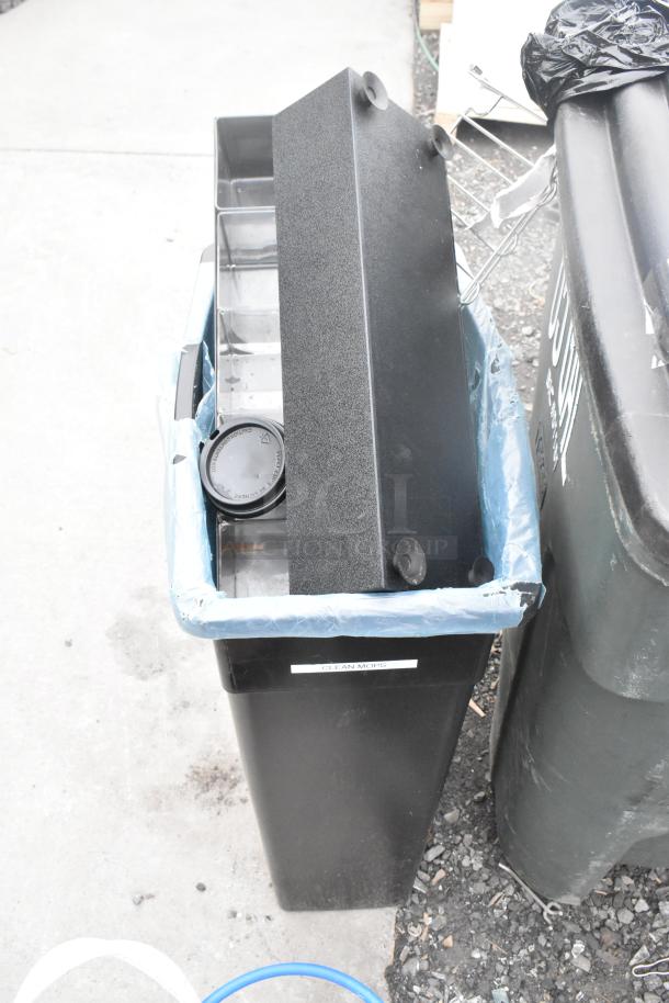 Two black poly trash cans with contents, featuring a "CLEAN MOPS" label. Condition appears used.
