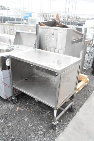Stainless steel table with under shelf, mounted on commercial casters. Ideal for kitchen use; sturdy and mobile. Good condition.