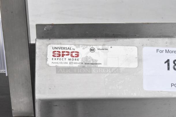 Universal by SPG stainless steel 3 bay sink with dual drain boards and under shelf, labeled NSF. Visible wear and scratches.