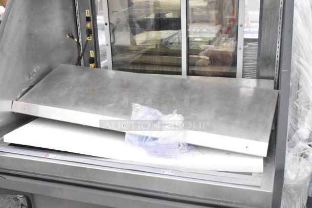 Metal Commercial Reach In Grab N Go Merchandiser, features stainless steel construction, shelves, electrical plugs, and glass front.