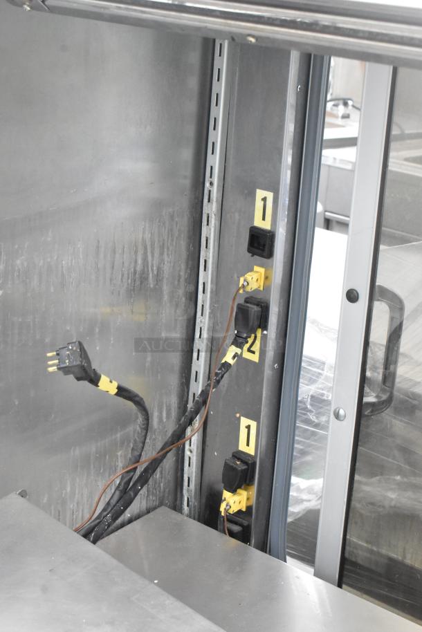 Metal Commercial Reach In Grab N Go Merchandiser with internal electrical components and labeled outlets. Slight wear visible.