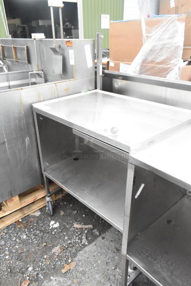 Stainless steel table with drawer, under shelf, and commercial casters; used condition, ideal for kitchen or workspace.