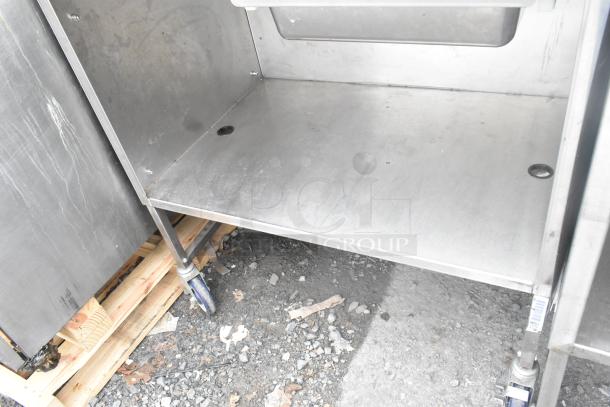 Stainless steel table with drawer and under shelf, on commercial casters. Slight wear, ideal for workspace use.