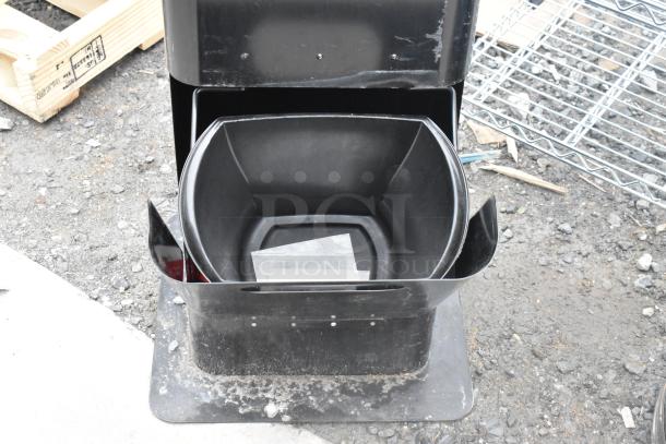 Black plastic trash cans set, open lid, sturdy design, used condition, dirt visible, includes inner container.