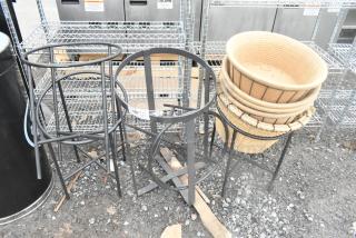 Five various metal stands, black finish, suitable for indoor or outdoor use, stacked baskets included, good condition.