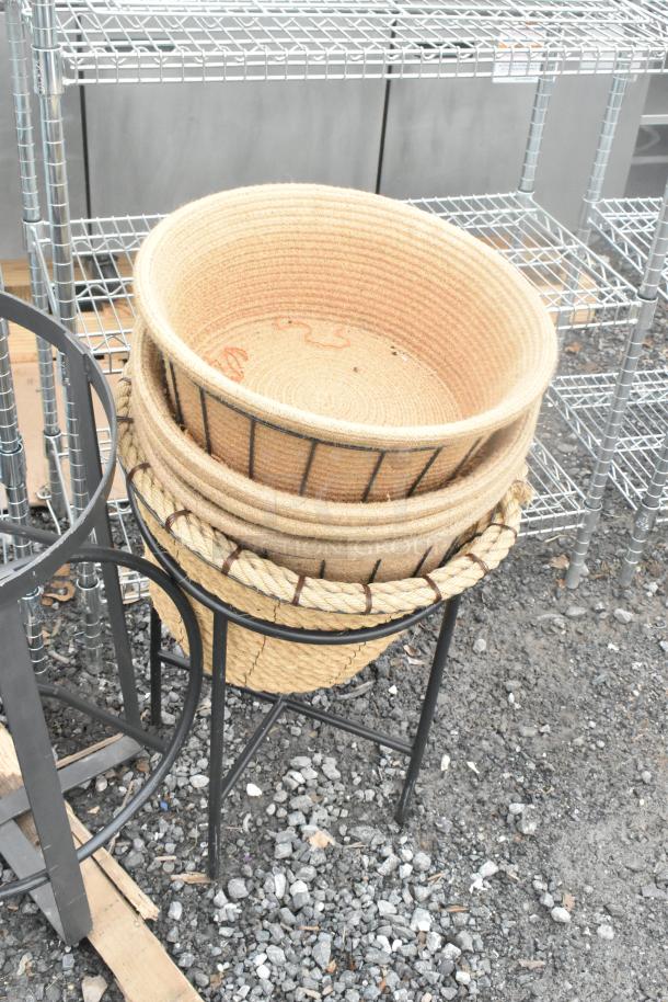 Five metal stands with woven baskets, sturdy condition, suitable for decorative or practical use in various settings.