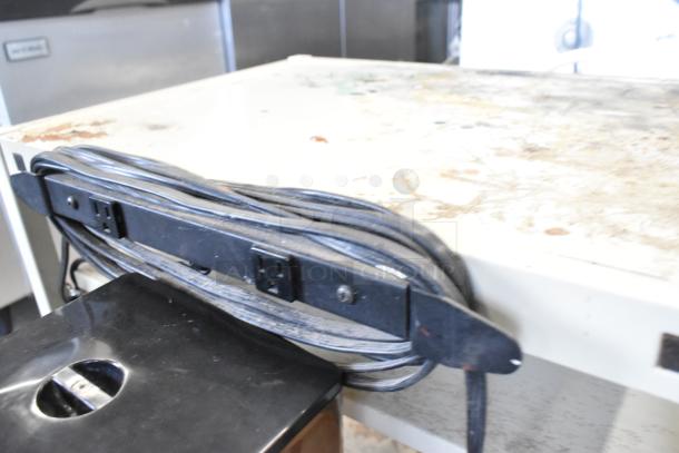 Alt text: Metal 4 tier cart with commercial casters, features built-in power strip and worn surface, ideal for utility use.